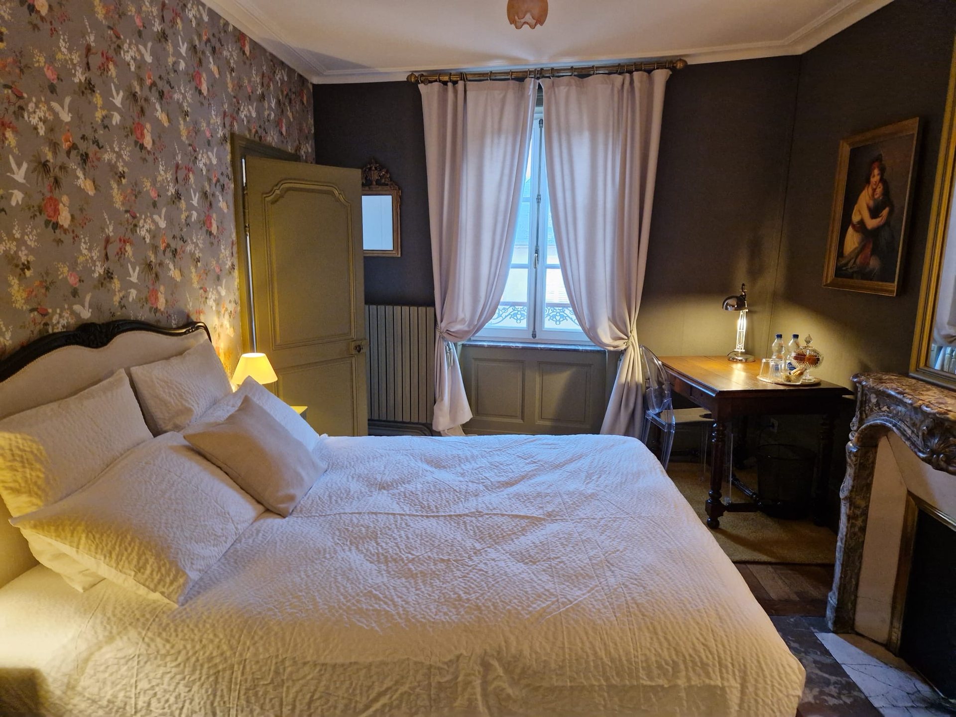 Chambre La Bagatelle de La Balsamine : lit double, papier peint fleuri et fenêtre à la française