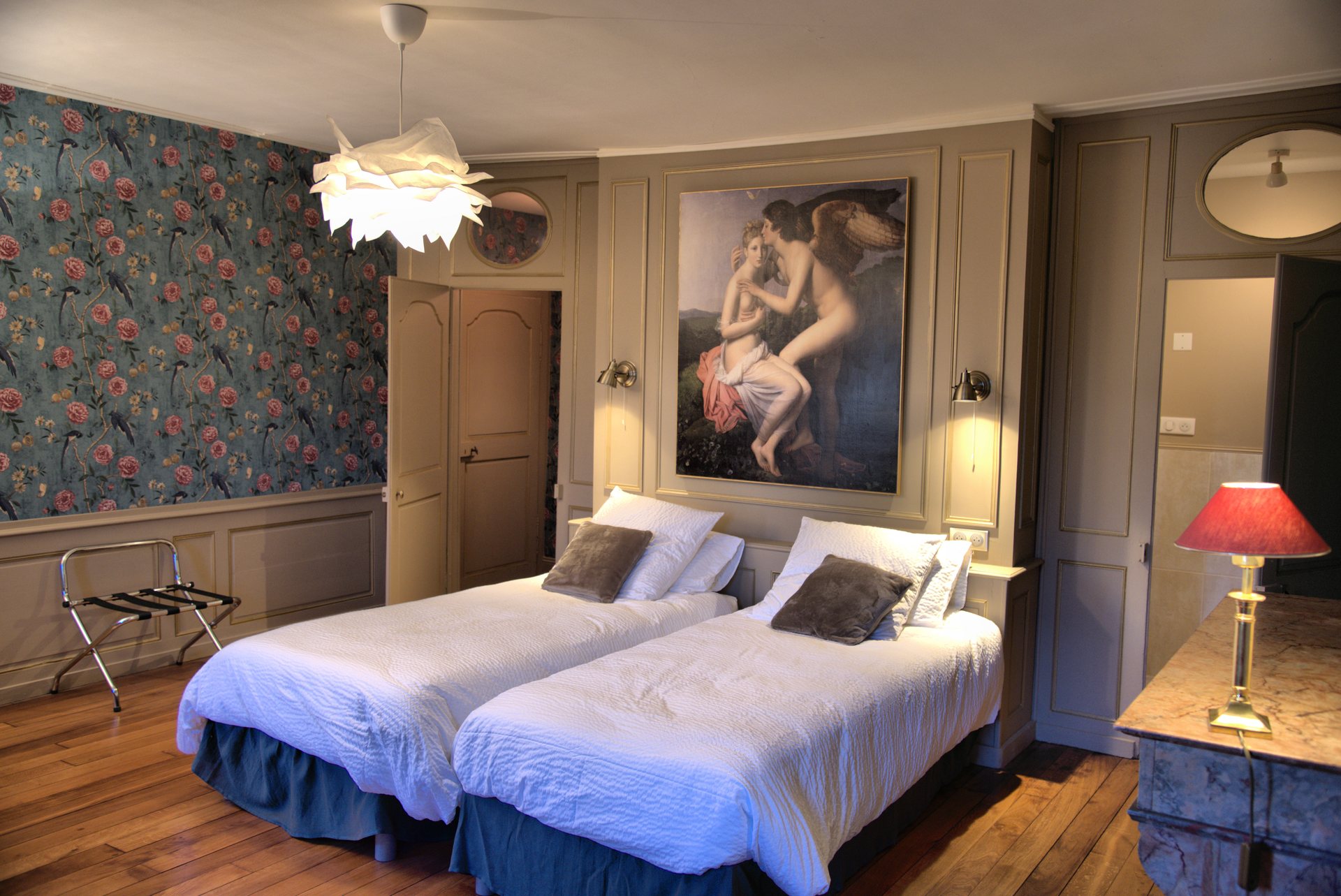 Chambre Cupidon : lits jumeaux sous la toile de Cupidon et papier peint fleuri