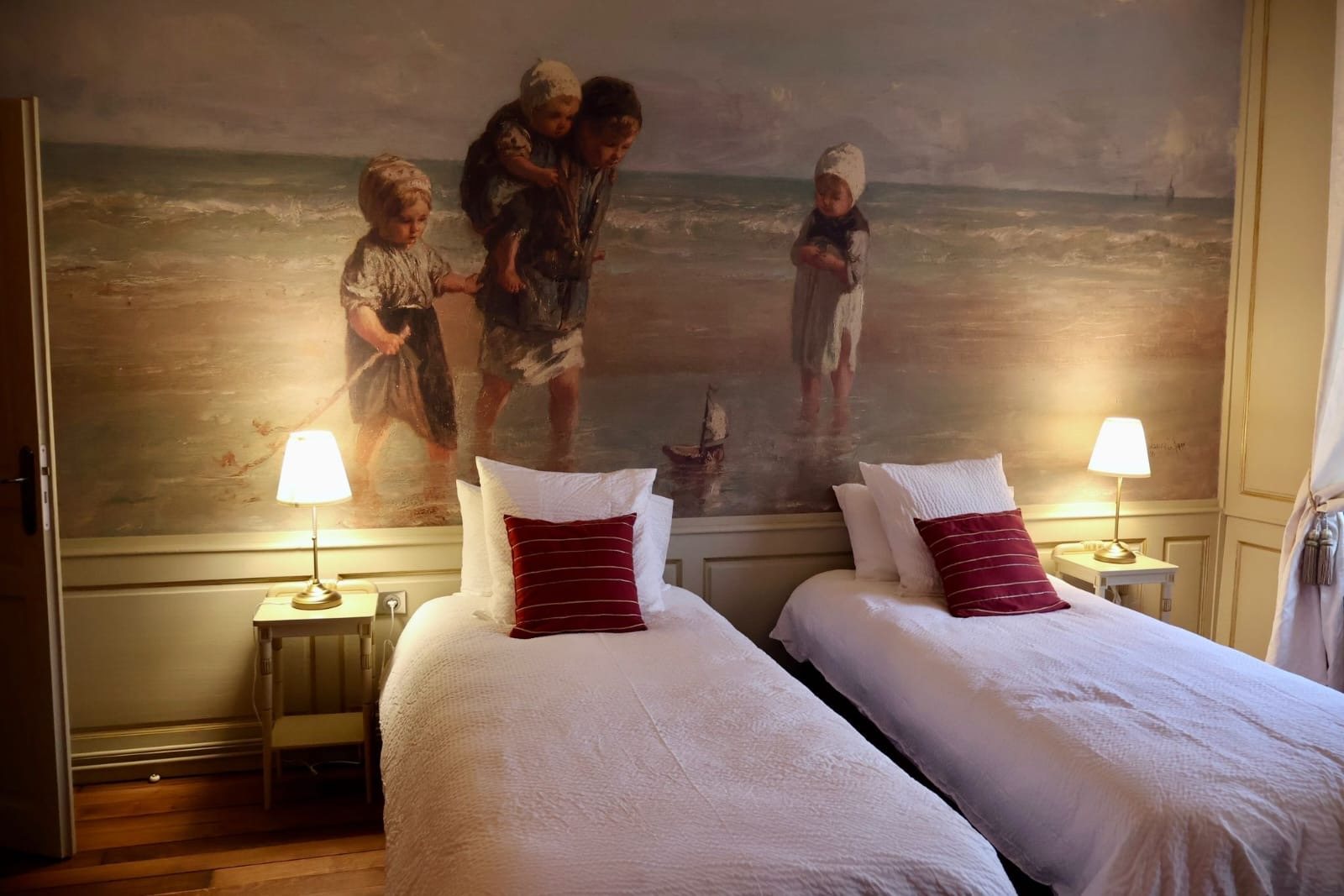 Détail de la fresque marine au-dessus des lits jumeaux et des coussins grenat