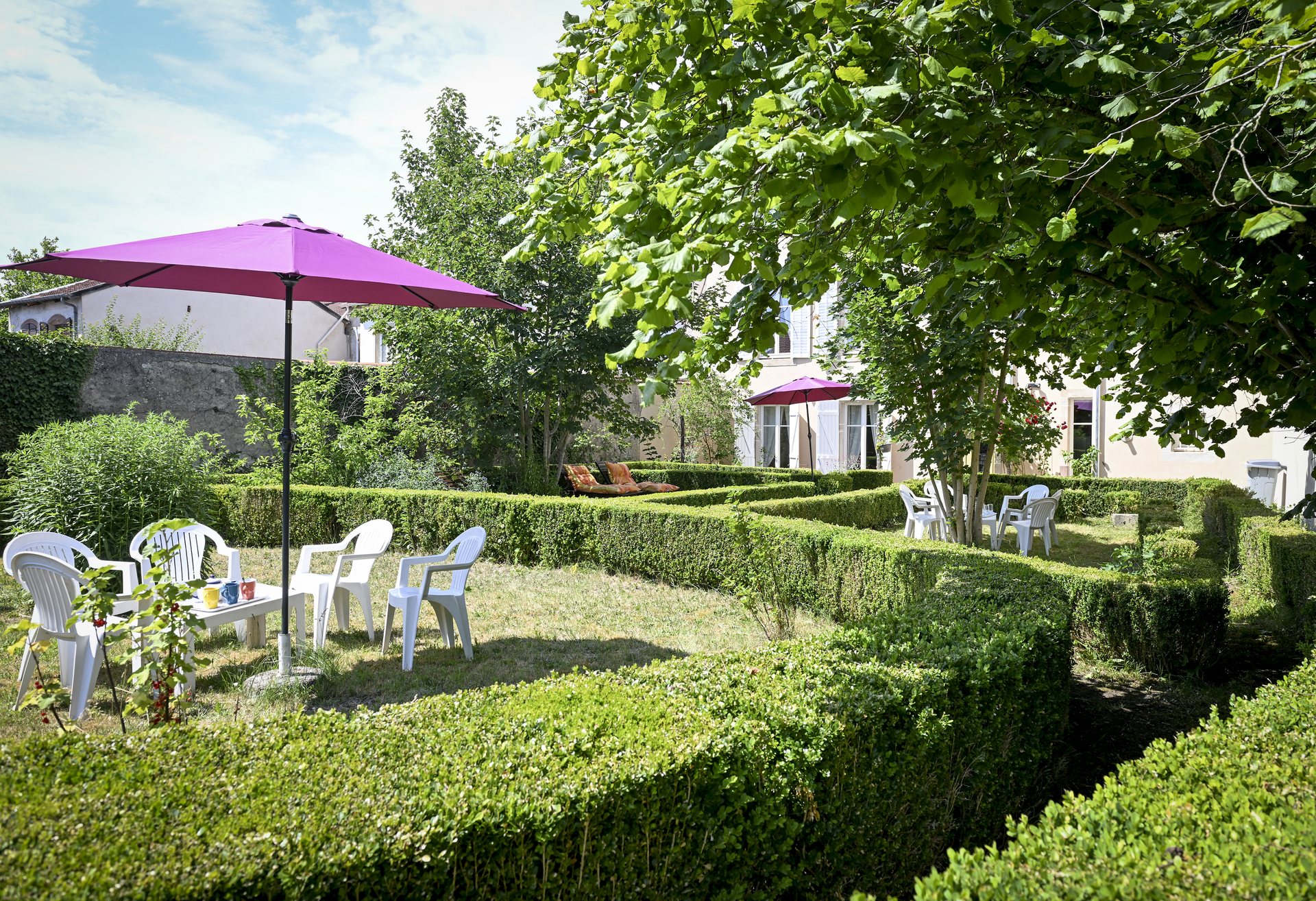 Salon de jardin sous les parasols dans le jardin clos de La Balsamine