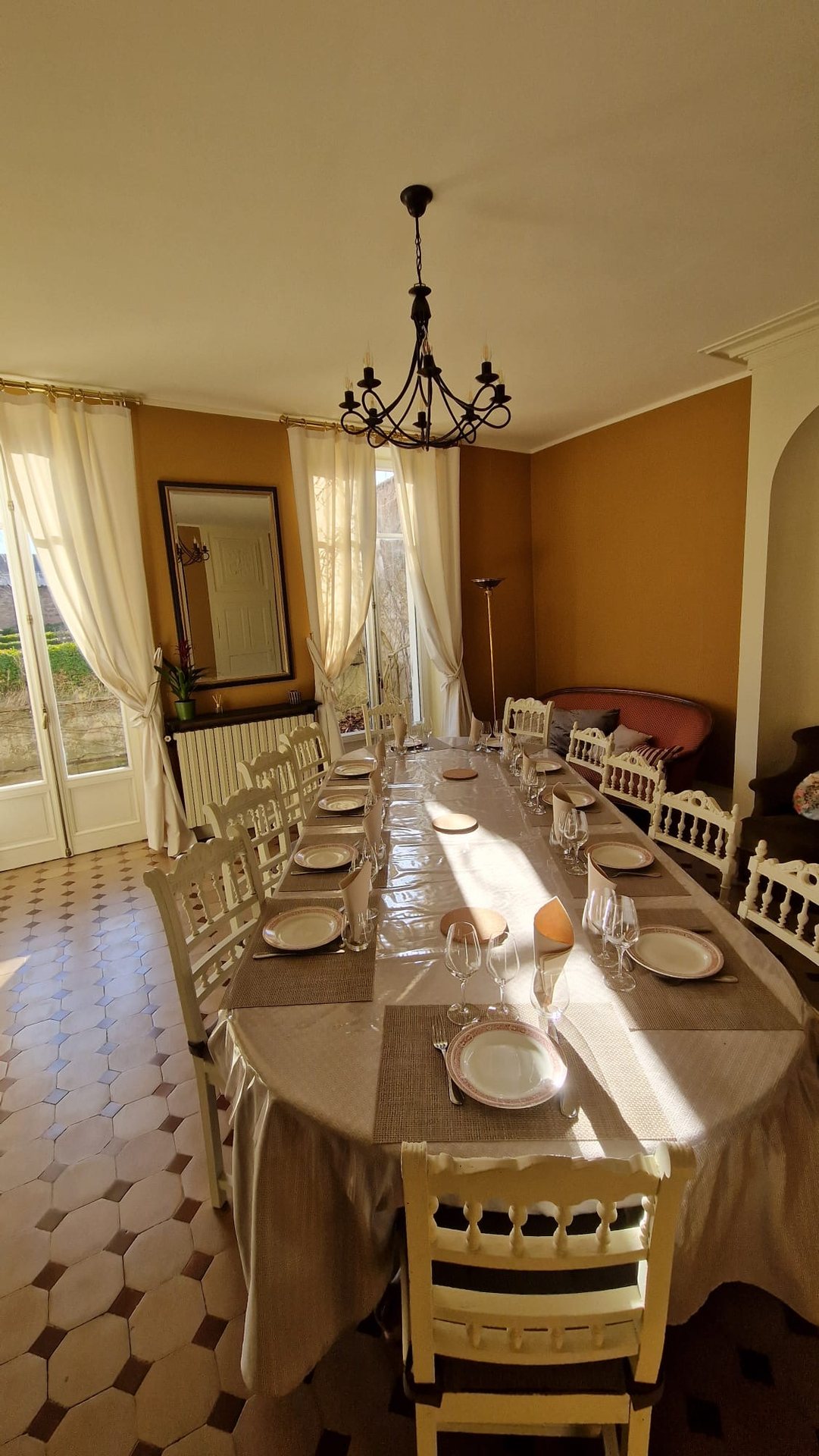 Enfilade de la table de douze couverts vers les portes-fenêtres