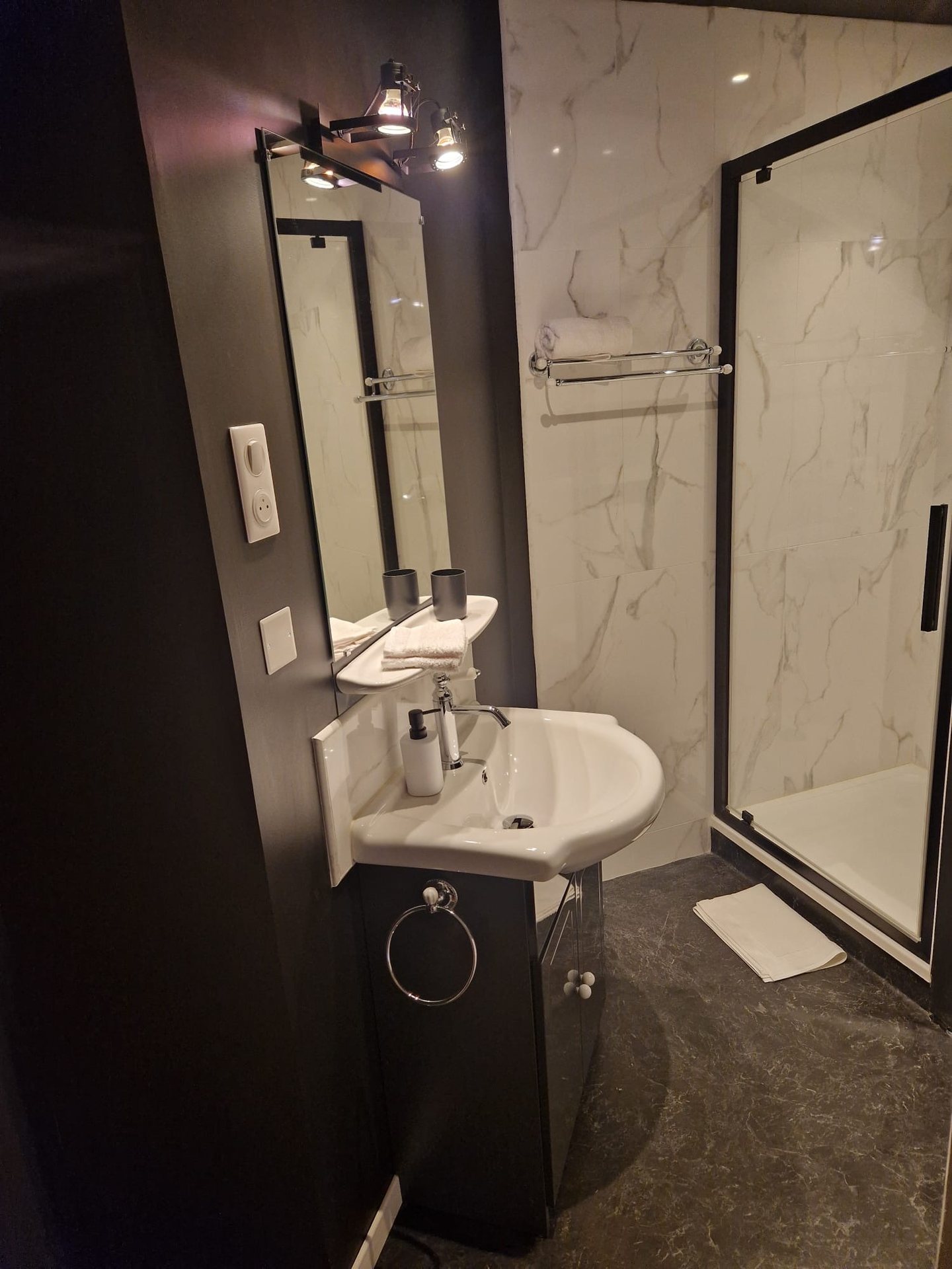 Salle d’eau privative de la chambre La Courtisane, marbre et robinetterie noire